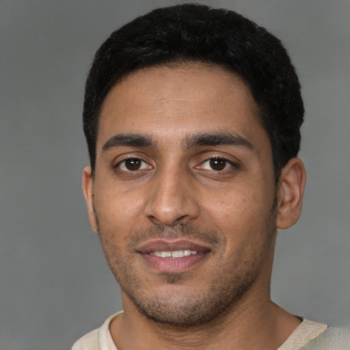 Joyful latino young-adult male with short  brown hair and brown eyes