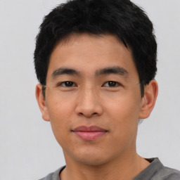 Joyful asian young-adult male with short  black hair and brown eyes