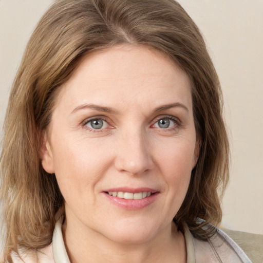 Joyful white adult female with medium  brown hair and grey eyes