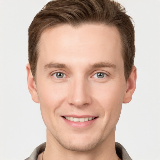 Joyful white young-adult male with short  brown hair and grey eyes