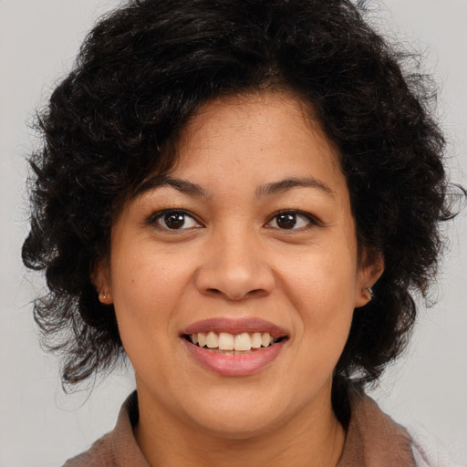 Joyful latino young-adult female with medium  brown hair and brown eyes