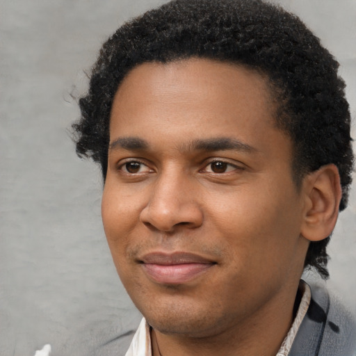 Joyful black young-adult male with short  black hair and brown eyes