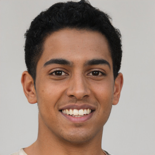 Joyful latino young-adult male with short  brown hair and brown eyes