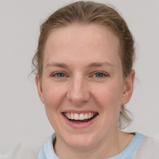 Joyful white young-adult female with short  brown hair and blue eyes