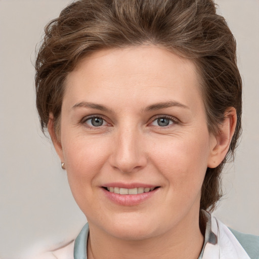 Joyful white young-adult female with short  brown hair and grey eyes