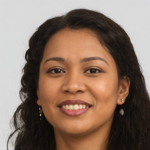 Joyful latino young-adult female with long  brown hair and brown eyes