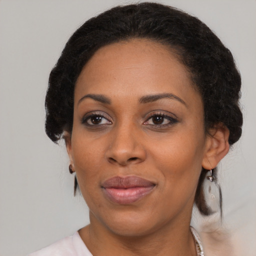 Joyful black adult female with medium  brown hair and brown eyes