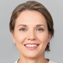 Joyful white young-adult female with medium  brown hair and grey eyes