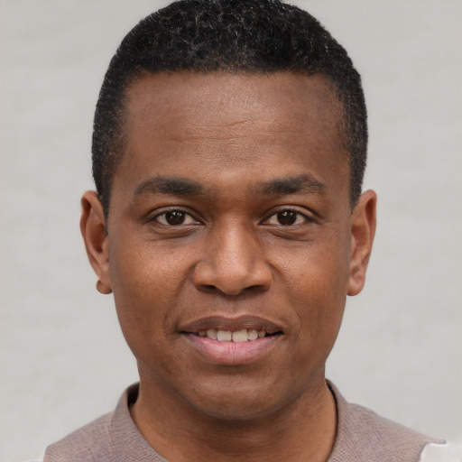 Joyful black young-adult male with short  black hair and brown eyes