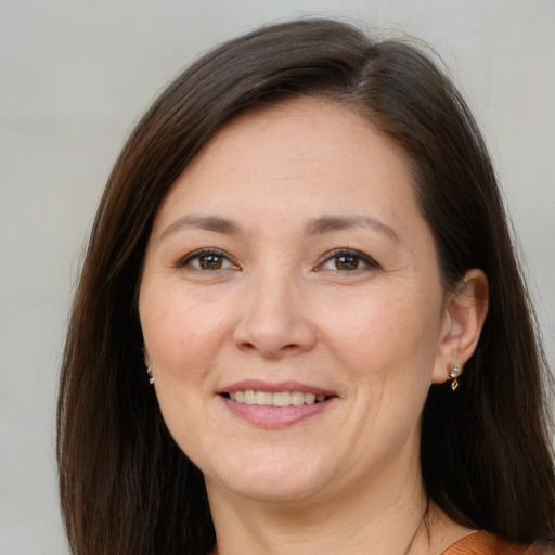 Joyful white adult female with long  brown hair and brown eyes