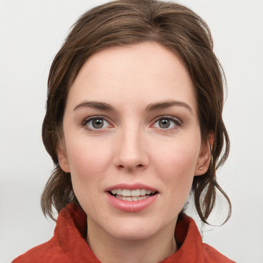 Joyful white young-adult female with medium  brown hair and grey eyes