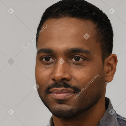 Joyful black young-adult male with short  black hair and brown eyes