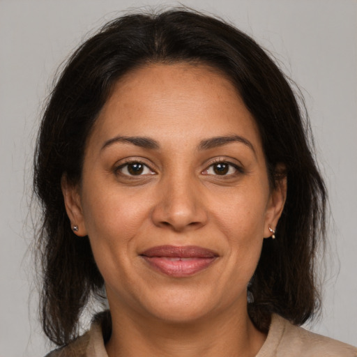 Joyful latino adult female with medium  brown hair and brown eyes