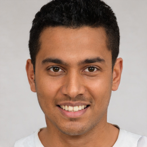 Joyful latino young-adult male with short  black hair and brown eyes