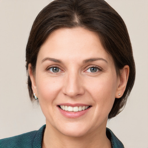 Joyful white young-adult female with medium  brown hair and grey eyes