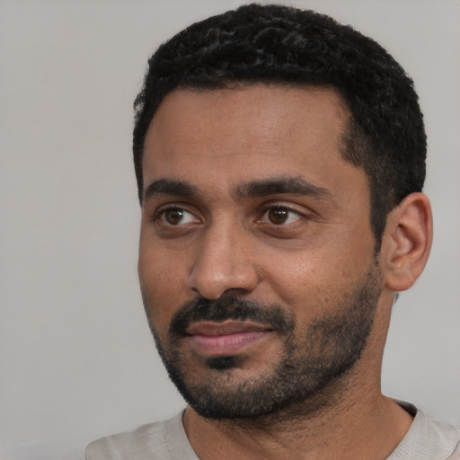 Joyful black young-adult male with short  black hair and brown eyes