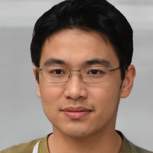 Joyful asian young-adult male with short  black hair and brown eyes