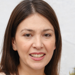 Joyful white adult female with long  brown hair and brown eyes