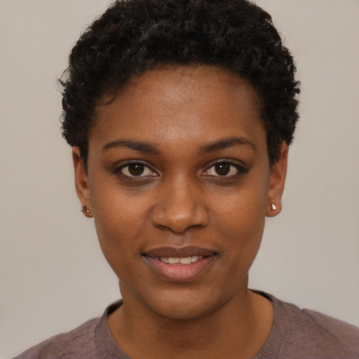 Joyful black young-adult female with short  black hair and brown eyes