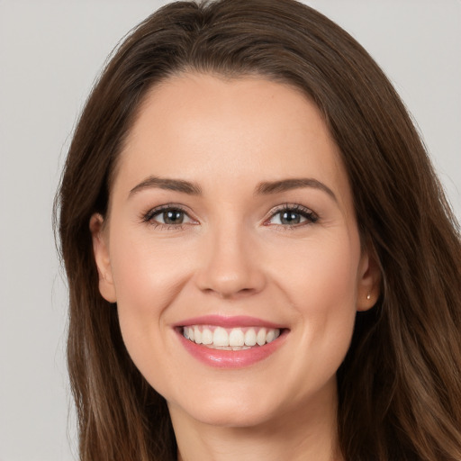 Joyful white young-adult female with long  brown hair and brown eyes