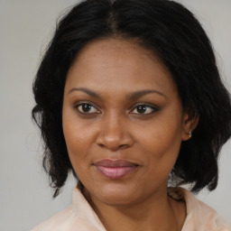 Joyful black adult female with medium  brown hair and brown eyes