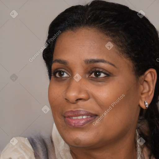 Joyful black young-adult female with long  brown hair and brown eyes