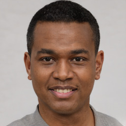 Joyful black young-adult male with short  black hair and brown eyes