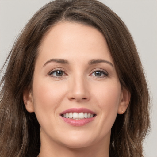 Joyful white young-adult female with long  brown hair and brown eyes