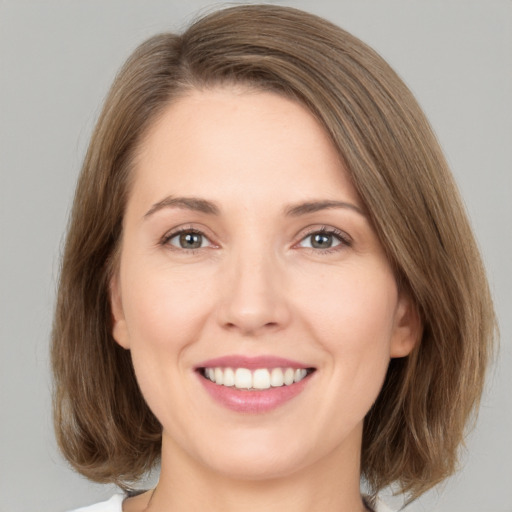 Joyful white young-adult female with medium  brown hair and green eyes