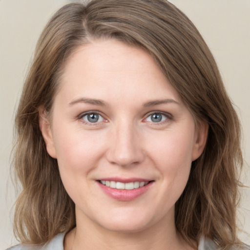 Joyful white young-adult female with medium  brown hair and grey eyes