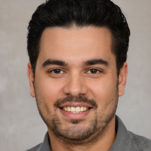 Joyful white young-adult male with short  black hair and brown eyes
