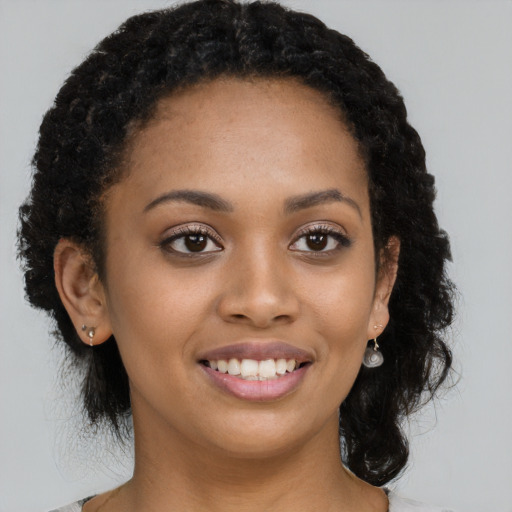 Joyful black young-adult female with long  black hair and brown eyes