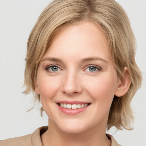 Joyful white young-adult female with medium  brown hair and blue eyes