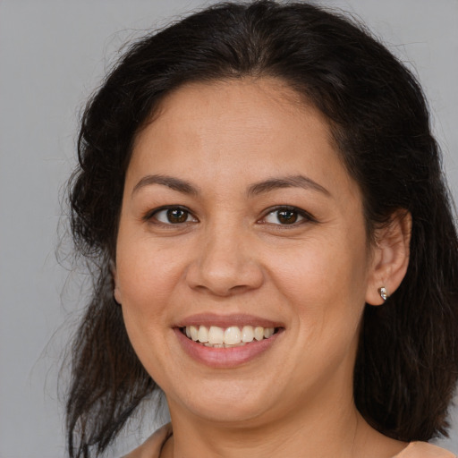 Joyful latino adult female with medium  brown hair and brown eyes