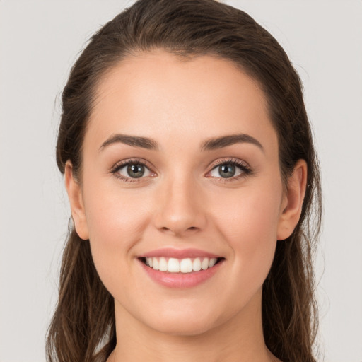 Joyful white young-adult female with long  brown hair and brown eyes