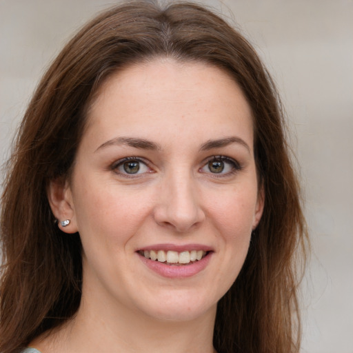 Joyful white young-adult female with long  brown hair and grey eyes