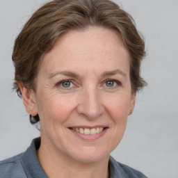 Joyful white adult female with medium  brown hair and grey eyes