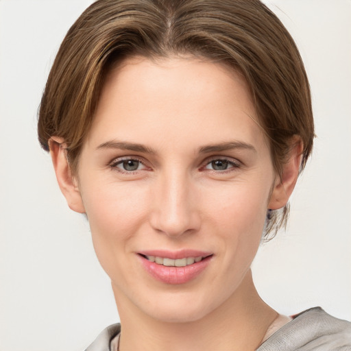 Joyful white young-adult female with short  brown hair and grey eyes