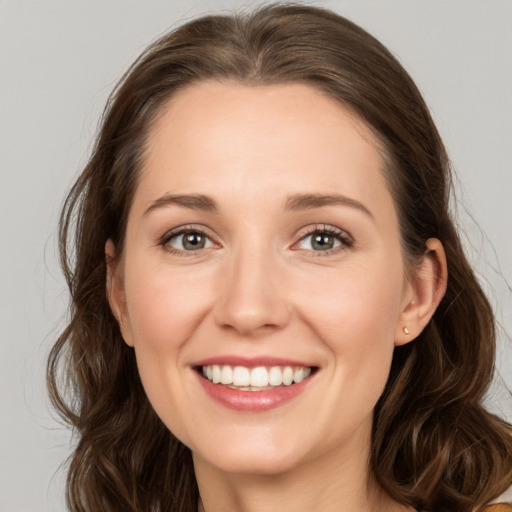 Joyful white young-adult female with long  brown hair and grey eyes