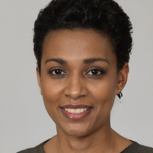Joyful black young-adult female with short  black hair and brown eyes