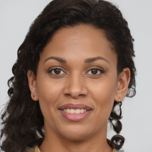 Joyful black young-adult female with long  brown hair and brown eyes