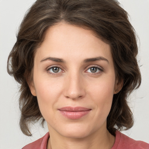 Joyful white young-adult female with medium  brown hair and green eyes