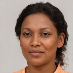 Joyful black adult female with medium  brown hair and brown eyes
