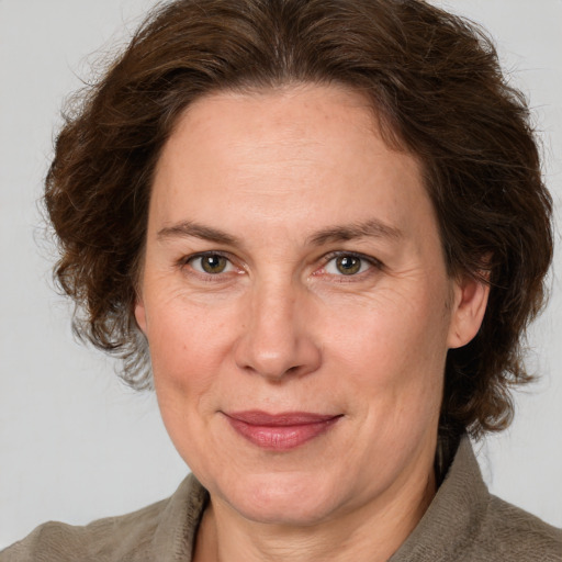 Joyful white adult female with medium  brown hair and grey eyes