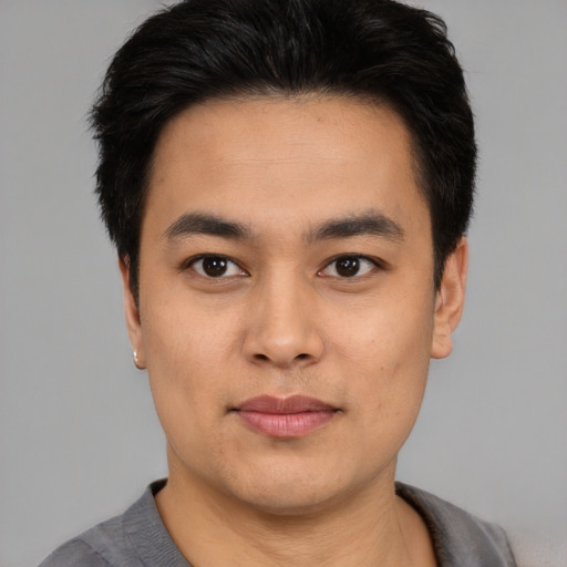 Joyful asian young-adult male with short  black hair and brown eyes