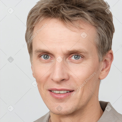 Joyful white adult male with short  brown hair and grey eyes