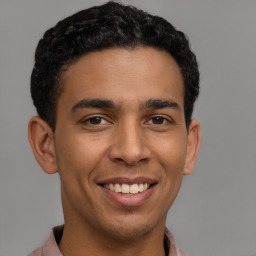 Joyful latino young-adult male with short  brown hair and brown eyes