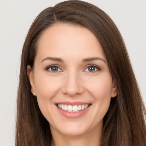 Joyful white young-adult female with long  brown hair and brown eyes