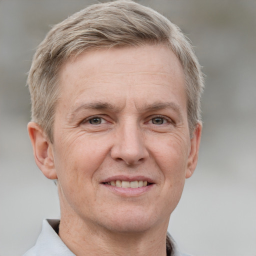 Joyful white adult male with short  brown hair and grey eyes