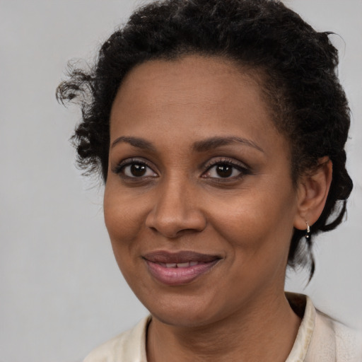 Joyful black young-adult female with short  brown hair and brown eyes